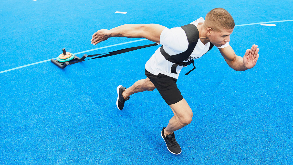 Man som drar en släde i sprint, träning inför Hyrox
