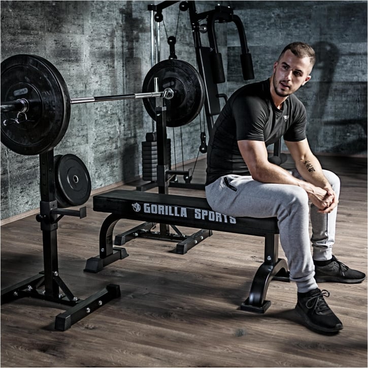 Man som tränar bänkpress med bänk, skivstång och skivstångsställ från gorilla sports