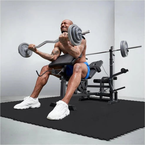 Man som tränar på en multibänkstation som är på ett gymgolv från gorilla sports