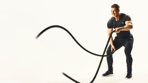 En man som tränar med battle ropes