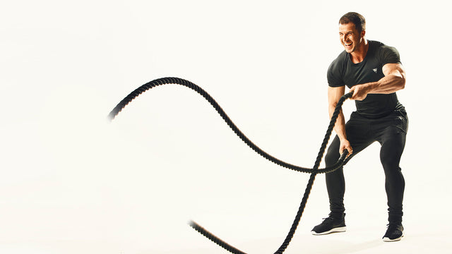 En man som tränar med battle ropes